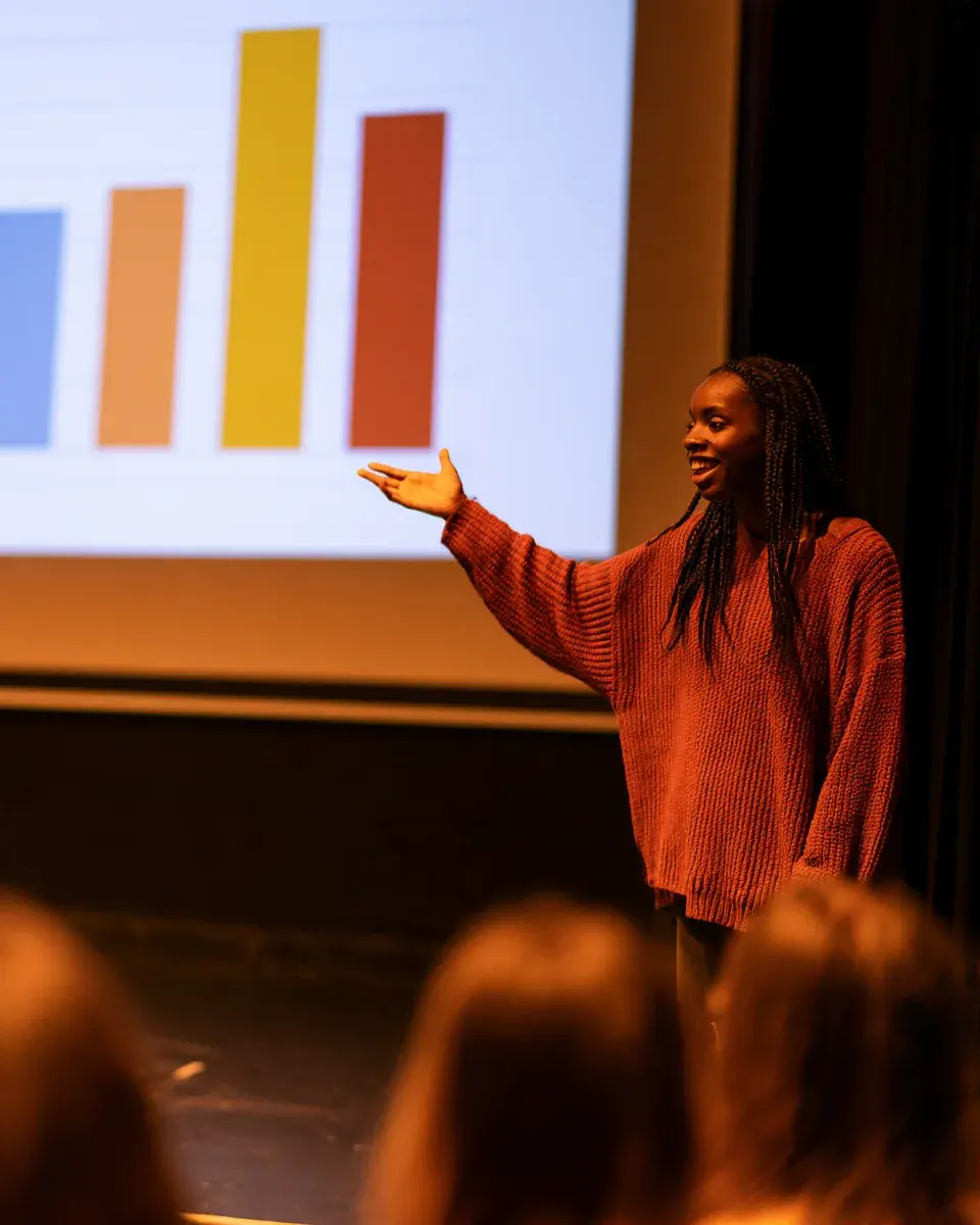 A student pitching on stage with slides